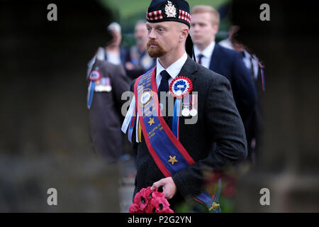 Selkirk, UK. 15th Jun, 2018.    Selkirk Common Riding - Hail Smilin Morn Caption: Ex Soldiers Standard Bearer, Martin Young on Friday 15 June 2018 waits to lay a wreath at the War Memorial while taking part in the town's Common Riding one of the oldest Borders festivals, in Selkirk, Scotland. The event dating from the Battle of Flodden in 1513, remembers the story of Flodden, when Selkirk sent 80 men into battle with the Scottish King. One man returned, bearing a blood stained English flag (Photo by Rob Gray / Freelance) Credit: Rob Gray/Alamy Live News Stock Photo
