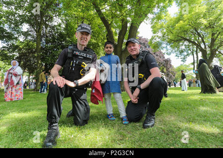 Birmingham, UK. 15th June, 2018. Over 100,000 muslims gather in Small Heath park, Birmingham, to pray on the morning of Eid, the end of the fasting month of Ramadan. Police take time to pose with children Peter Lopeman/Alamy Live News Stock Photo