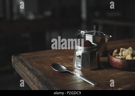 metal dishware with coffee and brown sugar in bowl on wooden tabletop Stock Photo