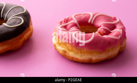 Pair of black and pink donuts isolated on colorful pink background Stock Photo