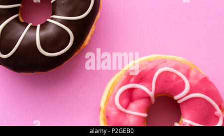 Pair of black and pink donuts isolated on colorful pink background Stock Photo