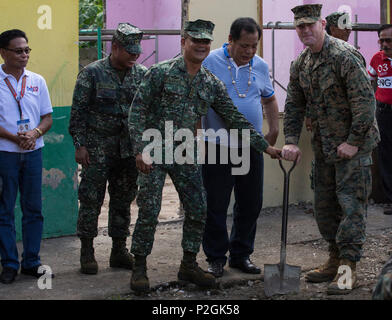 CAGAYAN, Philippines - U.S. Marine Capt. Andrew Nelson (right), humanitarian civic assistance officer in charge, Bravo Company, 9th Engineer Support Battalion, 3d Marine Logistics Group, breaks ground with Filipino Marines and Darwin A. Tobias (second from right), the municipal mayor of Santa Ana, Cagayan Province, during a ceremony for the engineering civic assistance project in support of Philippine Amphibious Landing Exercise 33 (PHIBLEX) Sept 23, 2016. PHIBLEX 33 is an annual U.S.-Philippine military bilateral exercise that combines amphibious landing and live-fire training with humanitari Stock Photo