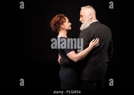 Half-length shot of man in a suit and a woman embracing each other Stock Photo