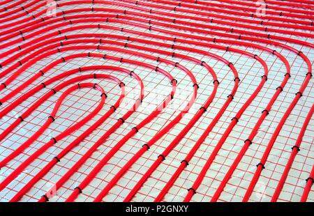 Water underfloor heating pipes on the silver reflective foil in house construction. Stock Photo
