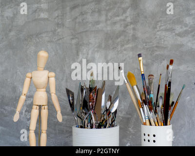 Wooden Figure, Brush, Trowel in The Artist Studio on Cement Background Stock Photo