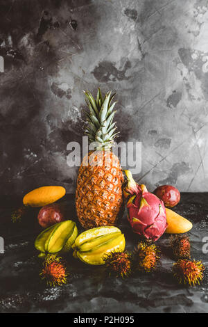 pitaya, rambutans, carambolas, mangoes, papayas and passion fruits on marble tabletop Stock Photo