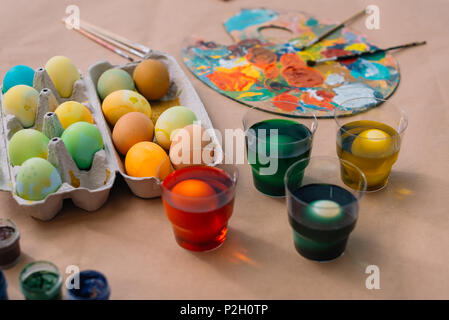 freshly painted easter eggs with paint on table Stock Photo
