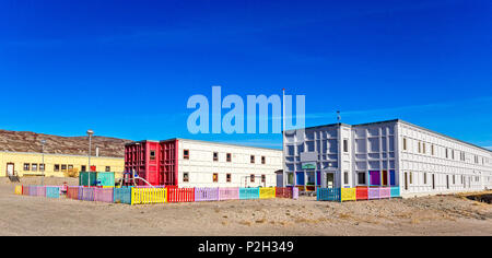 Modern greenlandic kindergarten with playground and colorful fence in tundra with rocky hills in the background, Kangerlussuaq, Greenland Stock Photo