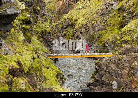 Person walking on a bridge over the river Emstrua, Laugarvegur, Fjallabak, South Island, Island Stock Photo