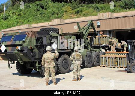 Soldiers pull a loaded flat rack off the loading dock with an Oshkosh M1075 Palletized Load System at the battalion’s ammunition holding area Sept. 20, at Camp Casey, South Korea. Soldiers of Alpha Battery, 1st Battalion, 82nd Field Artillery Battalion, 1st Armored Brigade Combat Team, 1st Cavalry Division, pulled the ammo to deliver to crews of M109A6 Paladin, self-propelled artillery vehicles, back at the Camp Hovey, South Korea, motor pool, as part of a load exercise. The flat racks were prepared ahead of time and ready to go once the bunkers were opened, in order to expedite the loading pr Stock Photo