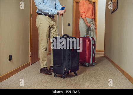 cropped shot of mature couple with suitcases standing in hotel hallway Stock Photo