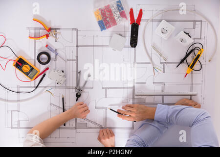 Elevated View Of Architect's Hand And Various Work Tools On Blueprint Stock Photo