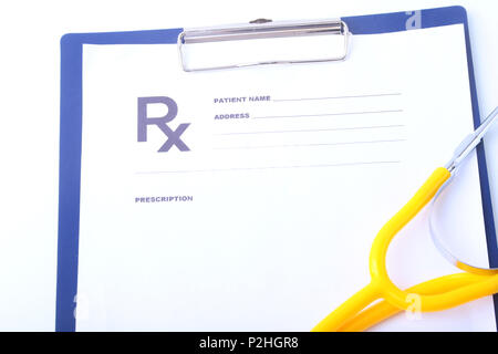 Closeup of medical stethoscope on a rx prescription, red heart isolated on white background. Stock Photo