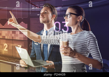 Calm woman pointing to the screen while working with a colleague Stock Photo
