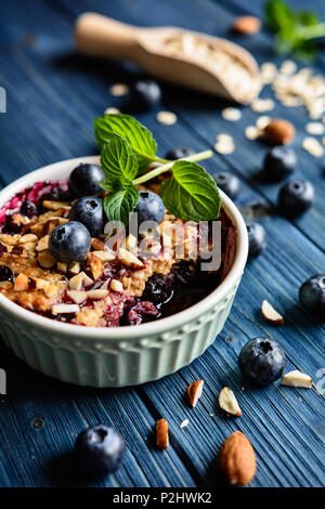 Baked blueberry crumble with oat flakes and chopped almonds Stock Photo