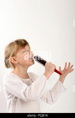 hairbrush diva, young girl singing into her haribrush Stock Photo