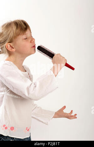 Hairbrush diva - young girl singing into her hairbrush Stock Photo