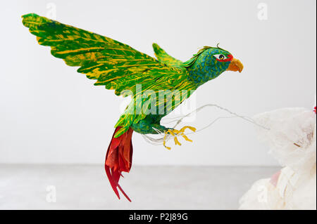 Paper parrot on mannequin's hand Stock Photo