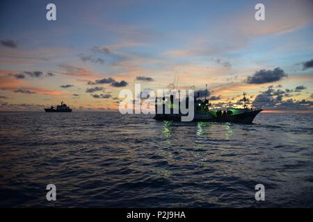 The USCGC Sequoia (WLB-215) maintains position off the Jinn Hsing Tsai No. 3 in the Philippine Sea while a joint boarding team conducts a boarding of the vessel to enforce fisheries regulations, Sept. 2, 2016. The U.S. Coast Guard and Australian Fisheries Management Authority boarded the vessel to ensure compliance with Western and Central Pacific Fisheries Convention regulations. (U.S. Coast Guard photo by Chief Petty Officer Sara Mooers) Stock Photo