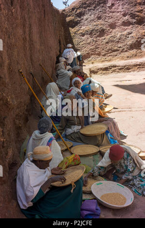 Women clean grain within the confines of one of Lalibela's rock-cut churches. Stock Photo