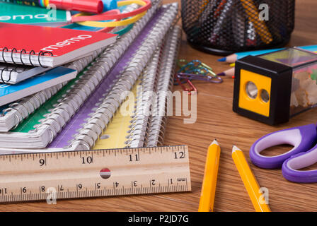 Closeup of an assortment of school supplies on a wooden desktop Stock Photo