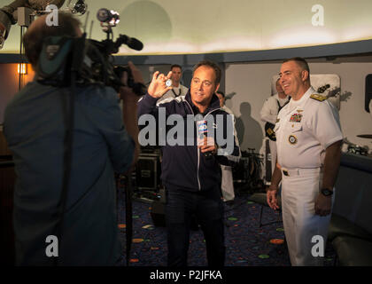 160929-N-KB426-190  SACRAMENTO, Calif. (Sept. 29, 2016) Gary Gelfand, a FOX40 reporter, observes Rear Adm. Douglas 'Woody' Beal’s, deputy commander of Navy Recruiting Command and flag host of Sacramento Navy Week,  challenge coin during a community relations event at the Powerhouse Science Center. Navy Weeks focus a variety of assets, equipment and personnel on a single city for a week-long series of engagements designed to bring America's Navy closer to the people it protects, in cities that do not have a large naval presence. (U.S. Navy photo by Petty Officer 3rd Class James Vazquez/Released Stock Photo