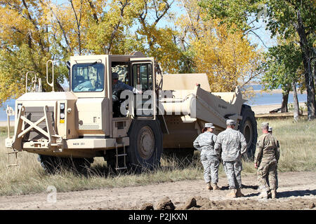 842nd Engineer Company is a unit of the South Dakota Army National Guard specializing in combat engineering and construction missions. The archival image documents soldiers discussing the next phase of a road construction project at Orman Dam near Belle Fourche, South Dakota, on October 1, 2016, in partnership with the Bureau of Reclamation to support military training access. Stock Photo