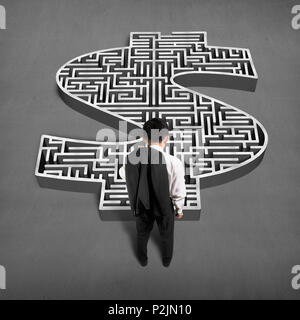 Businessman standing in front of 3d money shape maze on concrete ground Stock Photo