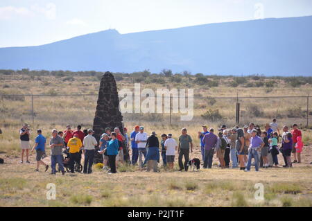 Visitors observe the obelisk marking ground zero at the Trinity Site during an open house at White Sands Missile Range, New Mexico, on October 1, 2016. The site commemorates the location of the first detonation of a nuclear device, providing historical context and educational information about the Manhattan Project and nuclear testing in the United States. Stock Photo