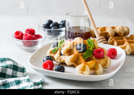 Traditional belgian waffles with blueberries and raspberries on white marble Stock Photo