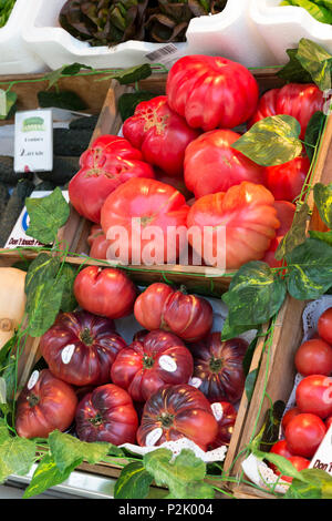 Madrid, Spain: Fresh heirloom tomatoes for sale at Mercado de San Miguel. Originally built in 1916, the landmark building was renovated and reopened i Stock Photo