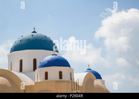brightly azure blue coloured greek chapel roofs on cyclade island Santorini with summer sky Stock Photo