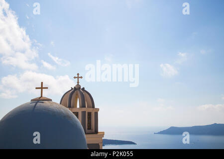 blue painted chapel domes on aegean island Santorini with summer sky and view over sea Stock Photo