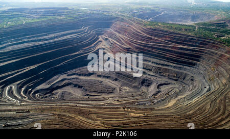 Aerial view of opencast mining quarry with lots of machinery at work. Stock Photo