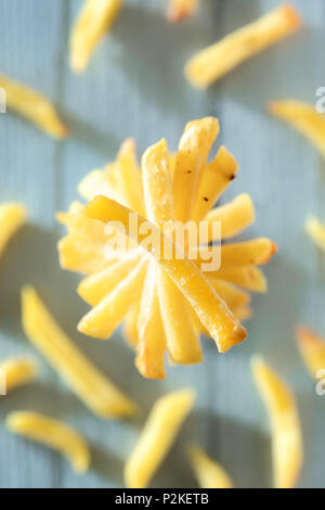 Stacked French Fries on Blue Wooden Surface Stock Photo