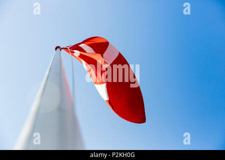 danish flag blowing in the wind, Baltic sea, Bornholm, near Gudhjem, Denmark, Europe Stock Photo