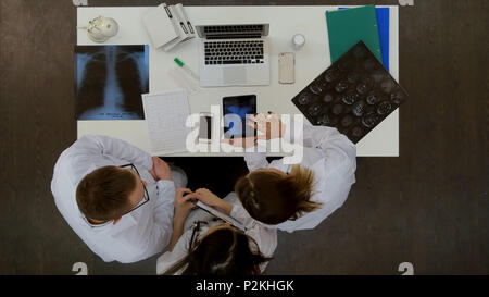 Male doctor showing xray on tablet to his medical team Stock Photo