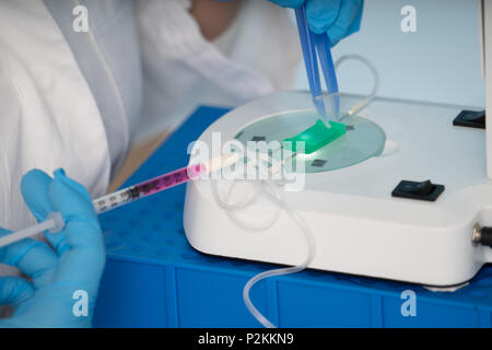 technician girl with microfluidic device LOC in microbiological lab Stock Photo