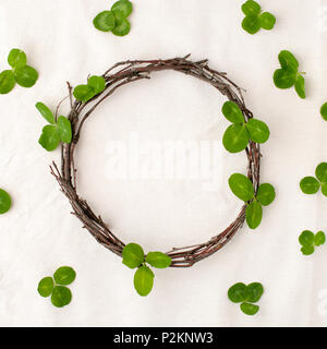 Floral composition. Wreath made of roools, leaves, and flowers on tissue white background. Rustic style of home decor, flat lay, top view. St.Patrick  Stock Photo