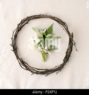 Floral composition. Wreath made of roools, leaves, and flowers on tissue white background. Rustic style of home decor, flat lay, top view. Stock Photo