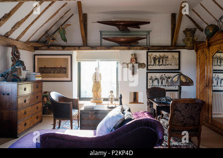 Purple chaise longue with statue in window and writing table lit by an original 60’s Tiffany lamp Stock Photo
