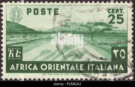 . Stamp of Italian East Africa; 1938; definitive stamp for the normal postmail - East African landscape with spaceiously savannah plain, two greater mountains, a central street and shades of head-carrying people on this street; Italian coat of arms in the left upper corner Stamp: Michel: No. 7; Yvert & Tellier: No. 7 Color: green Watermark: none Nominal value: 25 CENT. (Centesimo) Postage validity: from 7 February 1938 until 1941 . 7 February 1938 (first issue day of the stamp). Poste italiane SpA of the Ministry of Communications of the Kingdom of Italy 42 ITA EA 1938 MiNr007 pm B002 Stock Photo
