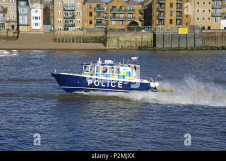 A London River Police launch patrols the River Thames at Wapping at high speed. Stock Photo