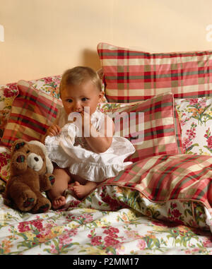 Smiling girl sitting with teddy bear on bench Stock Photo - Alamy