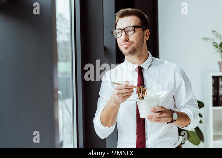 businessman holding box with noodles for lunch in office Stock Photo