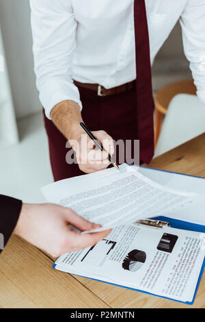 cropped view of businesspeople working with documents and signing contract Stock Photo