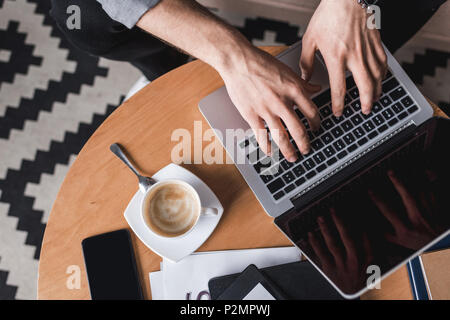 cropped shot fo man using laptop on coffee table Stock Photo