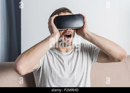 shocked young man in virtual reality headset Stock Photo