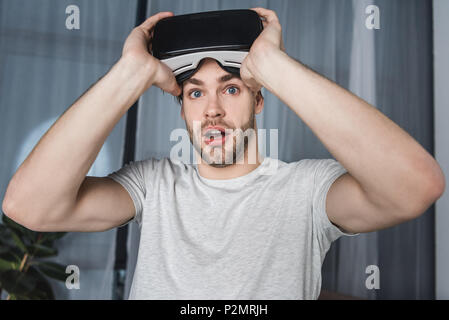 shocked young man in virtual reality headset Stock Photo