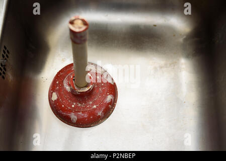 A plunger used to clean a clogged / blocked kitchen sink Stock Photo